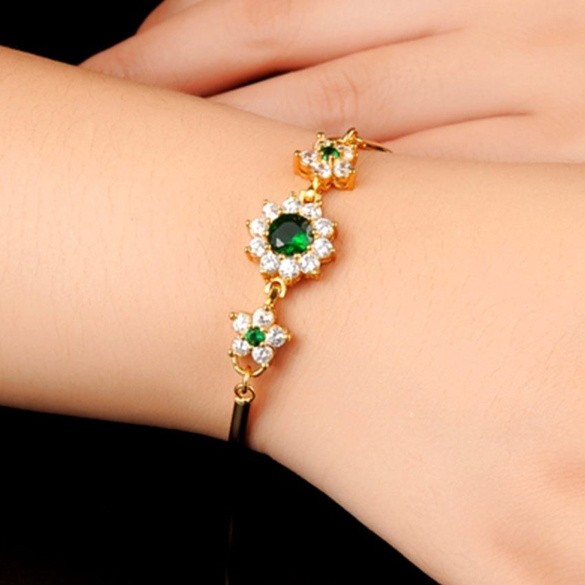 women hand with emerald cubic zirconia diamond flower design bangle bracelet